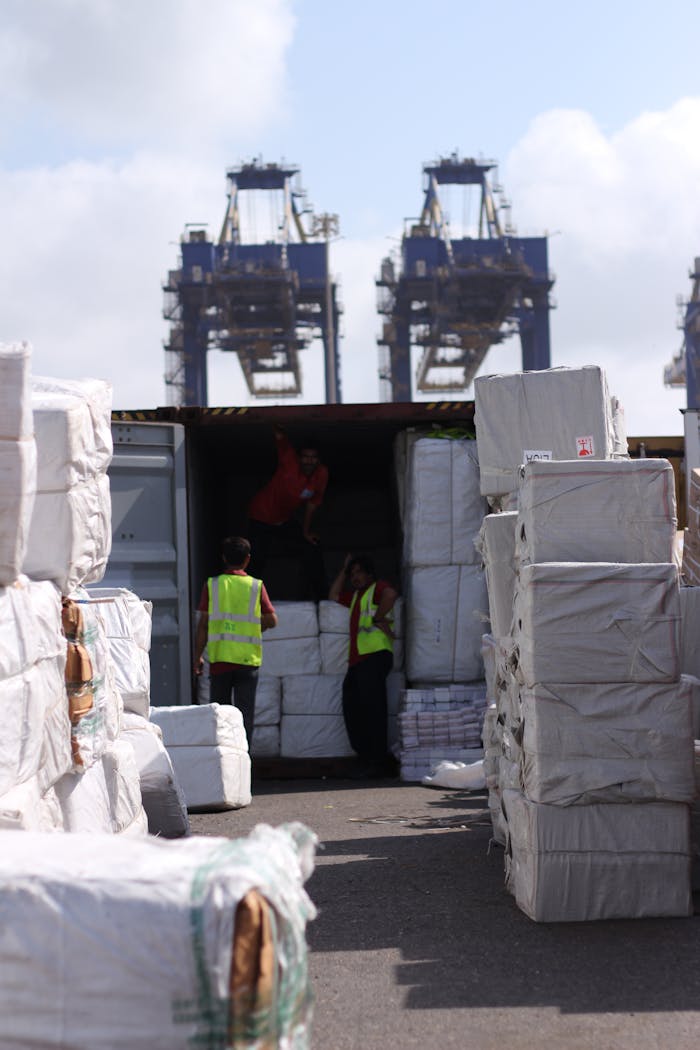 about-01 Dock workers loading cargo at Karachi Port with visible cranes and containers.